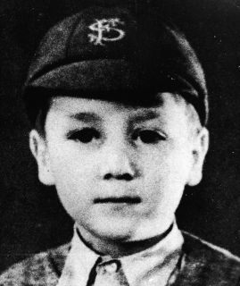 Headshot portrait of British musician and songwriter John Lennon (1940 -1980), of the pop group The Beatles, as a young boy in a school uniform and cap, c. 1948.