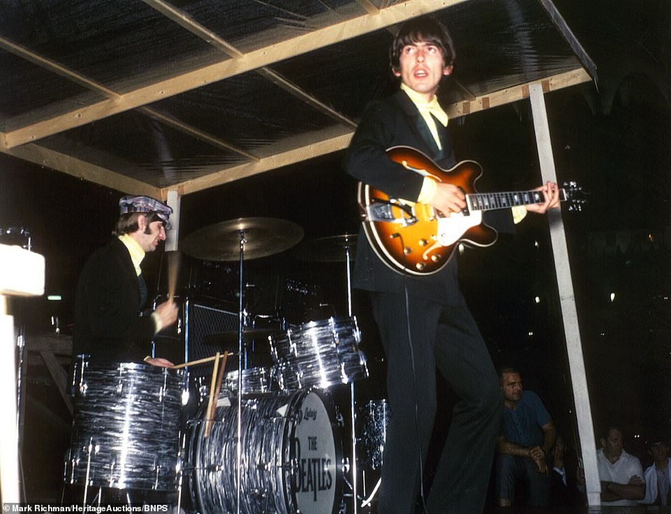 George Harrison plays guitar in front of drummer Ringo Starr at the rain-soaked concert at the Busch Stadium in St Louis, Missouri in 1966