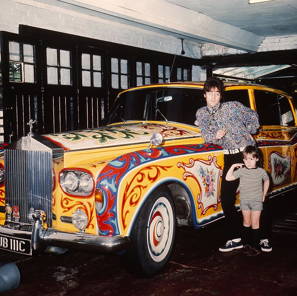 John Lennon and Julian Lennon leaning against the painted Rolls Royce